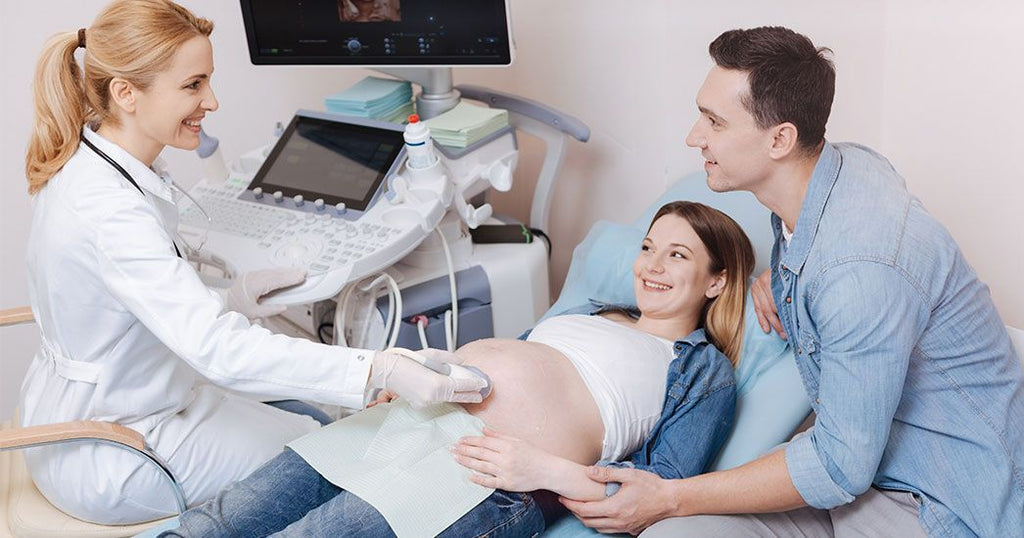Zwanger koppel bij de verloskundige pretecho maken