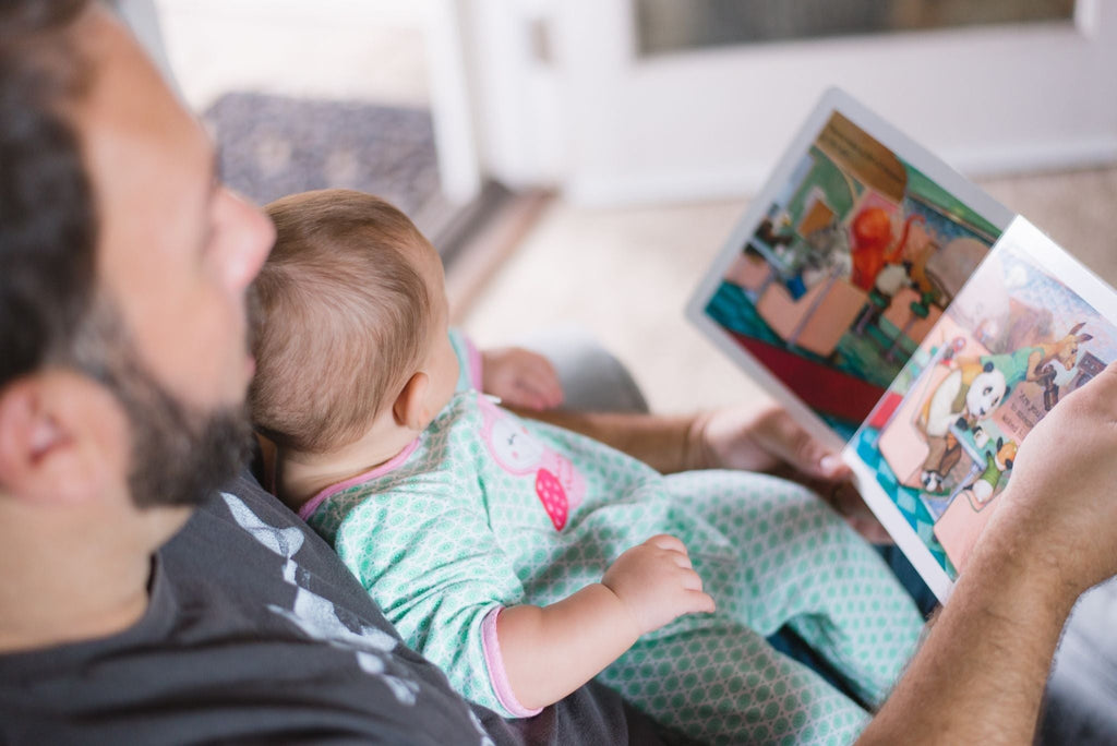 Papa leest een boekje met baby